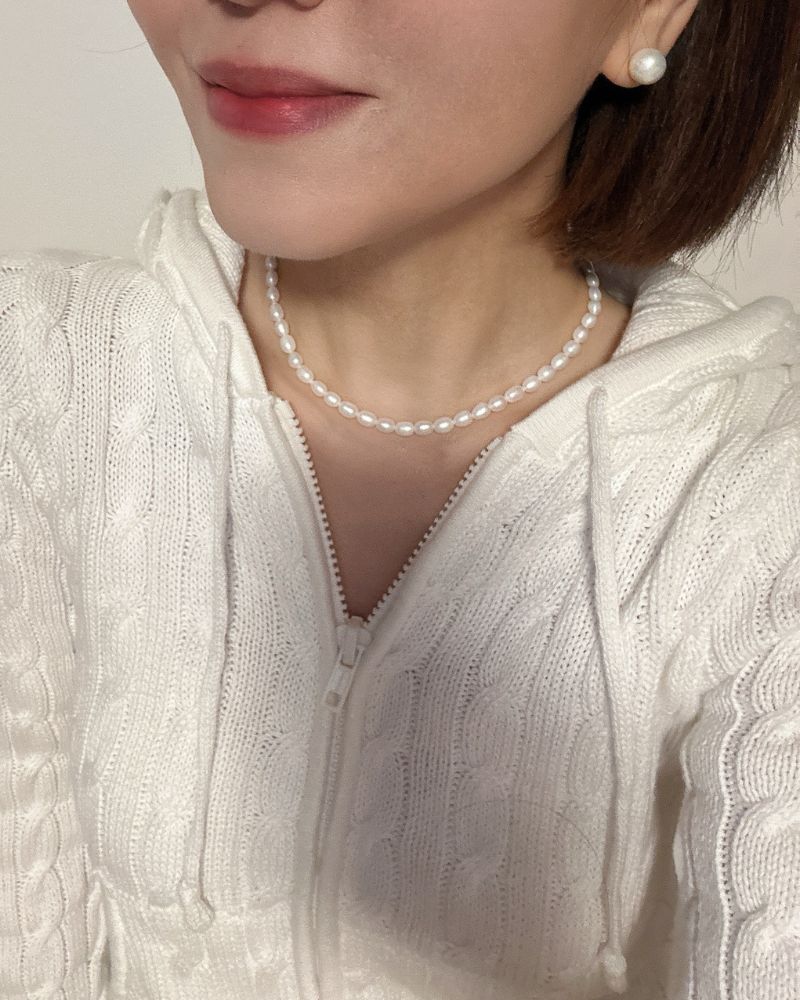 6 mm schneeweiße ovale Süßwasserperlenkette als halsnahe Kette getragen mit Perlenohrstecker