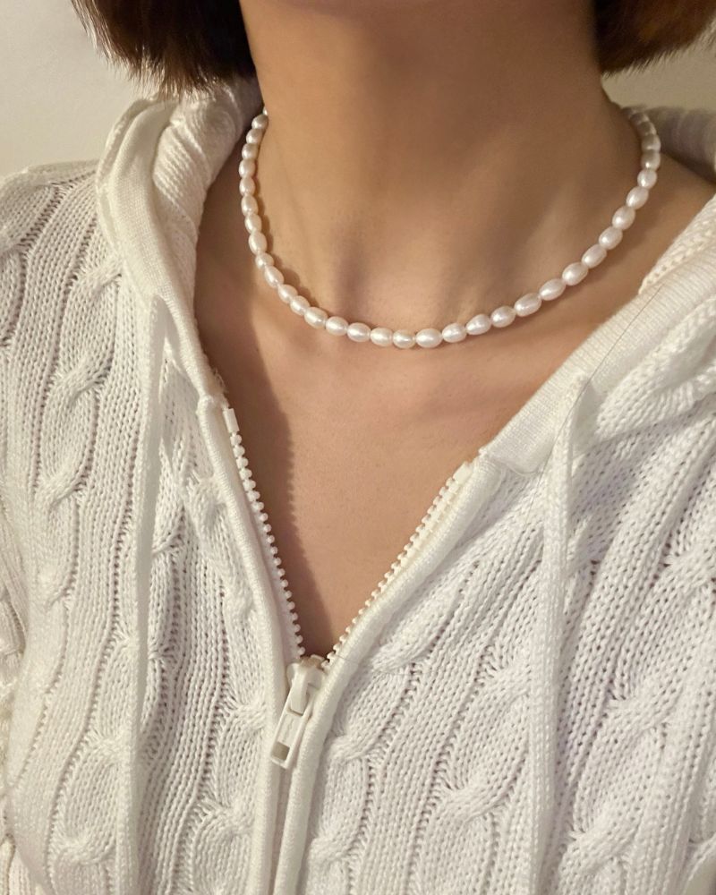 6 mm schneeweiße ovale Süßwasserperlenkette als halsnahe Kette getragen